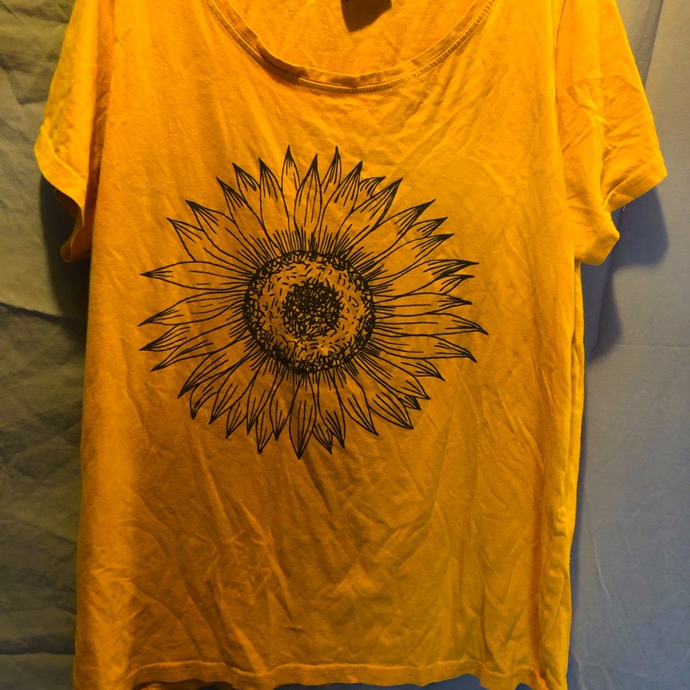 I’m selling a yellow t- shirt with a jumbo faded sunflower design in the back